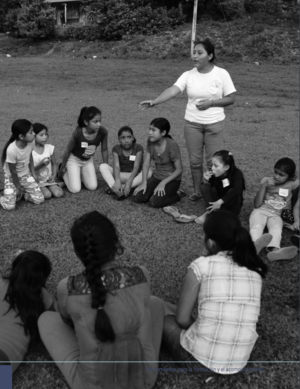 Facilitadora con grupo de niñas en círculo.png